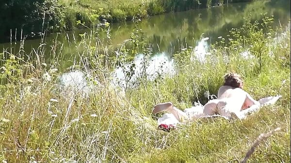 Nude Milf sunbathing on river bank. Random guy ...